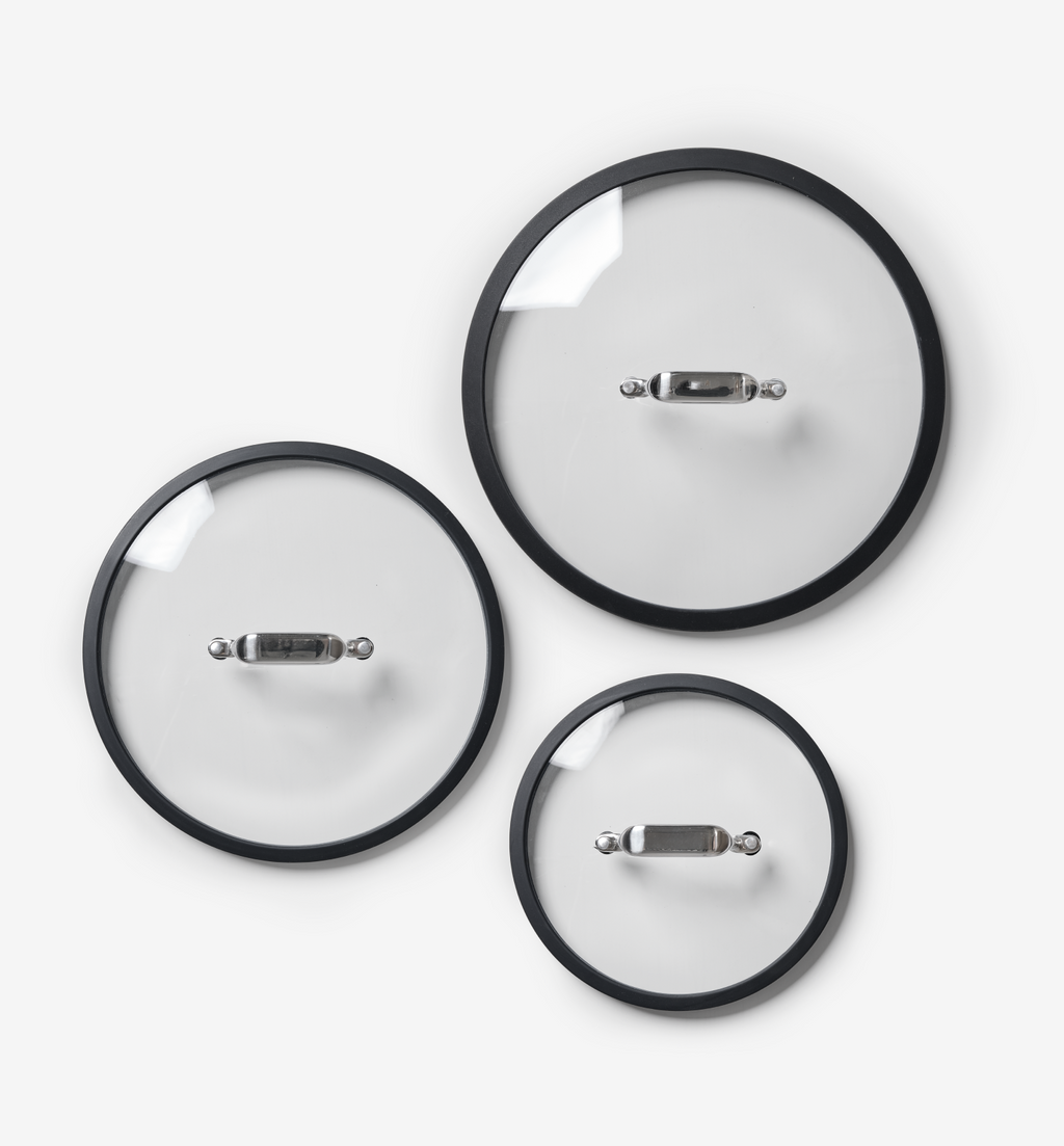 Set of three glass pot lids with black silicone rims and stainless steel handles in small medium large sizes